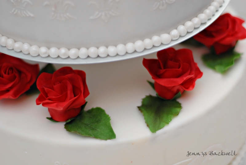 Hochzeitstorte mit roten Rosen